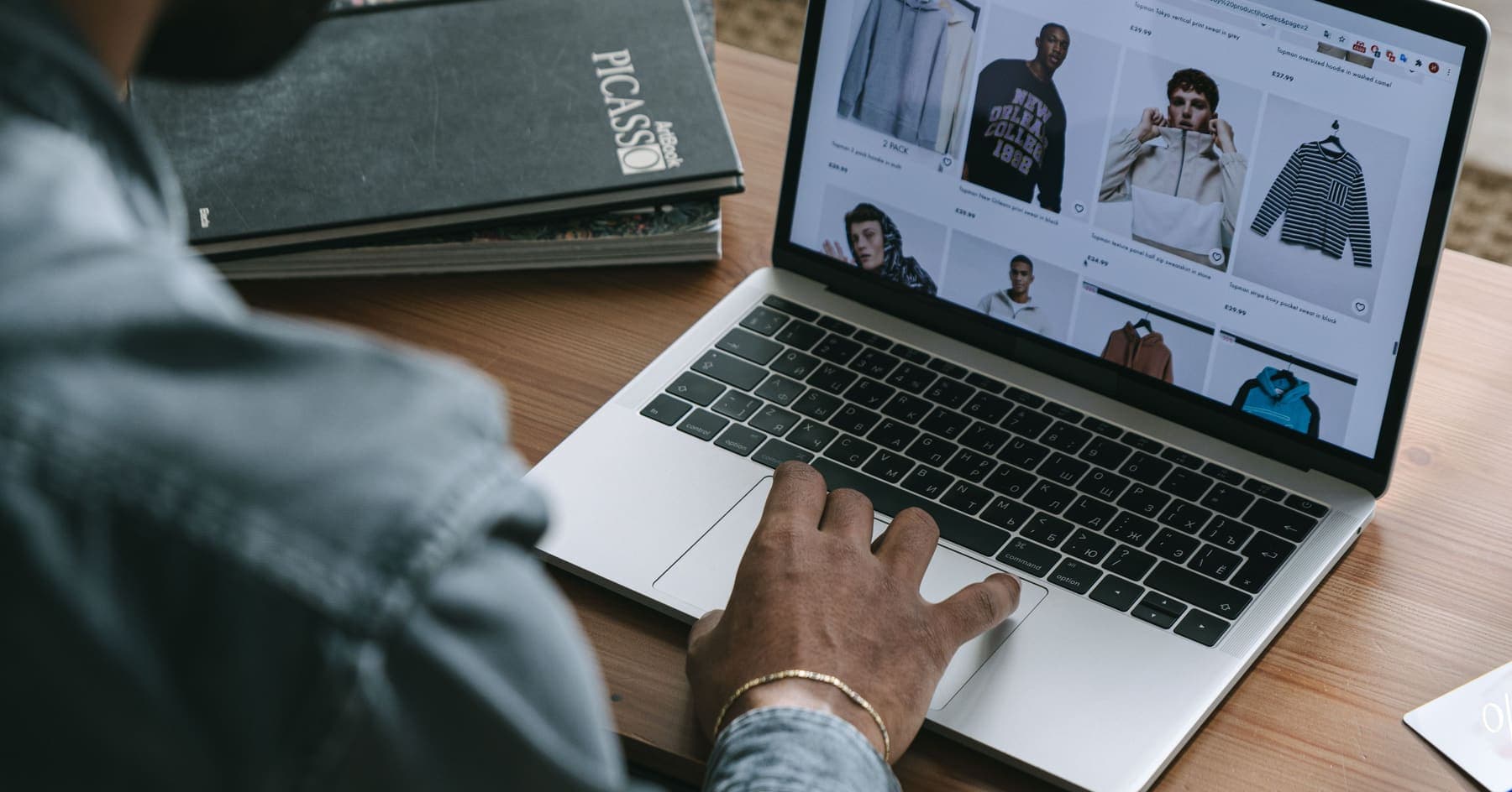 A shopper browsing an online clothing store on a laptop
