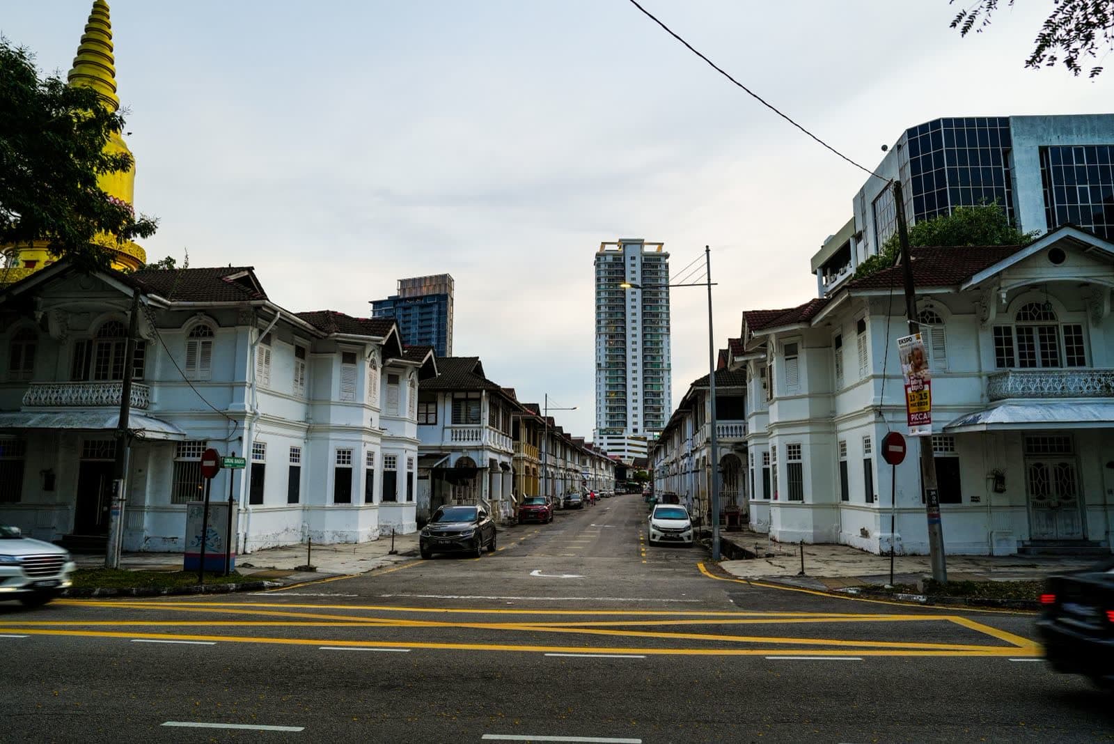 Colonial shophouses along Lorong Bangkok in George Town, Penang, a temple spire behind them