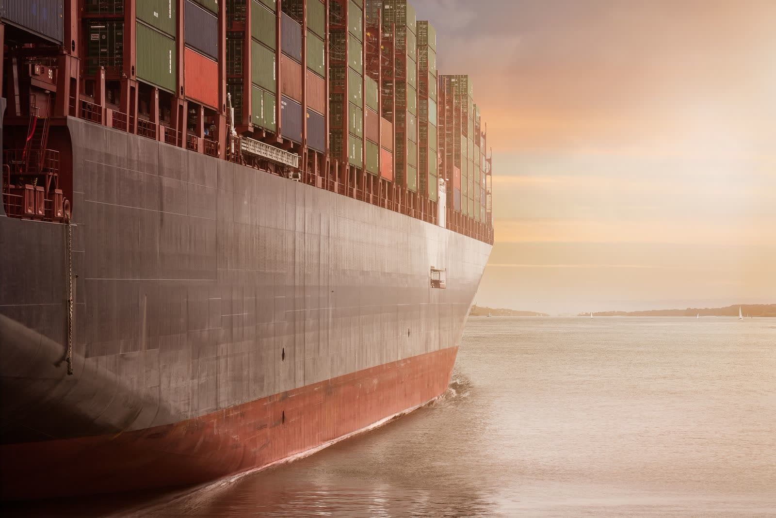 A loaded container ship at sea under an overcast sky